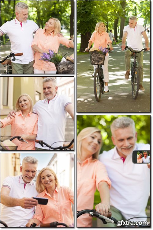 Mature, loving couple spending time together at park with bicycles - Stock photo