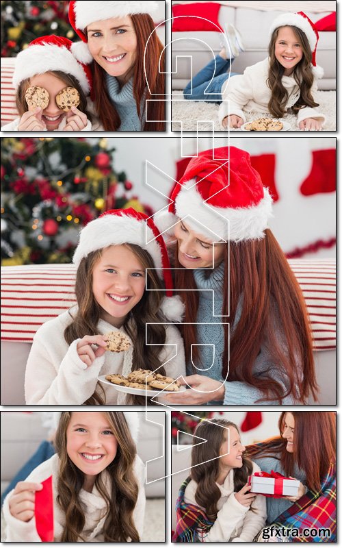 Festive mother and daughter wrapped in blanket with gifts - Stock photo